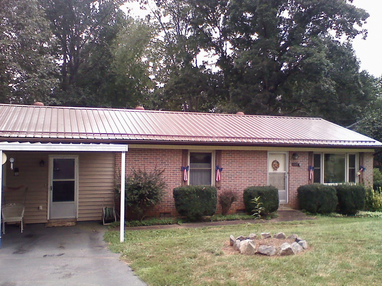 Bronze metal roof and carport on a brick ranch home — Roof Repair work by our crew in Delia